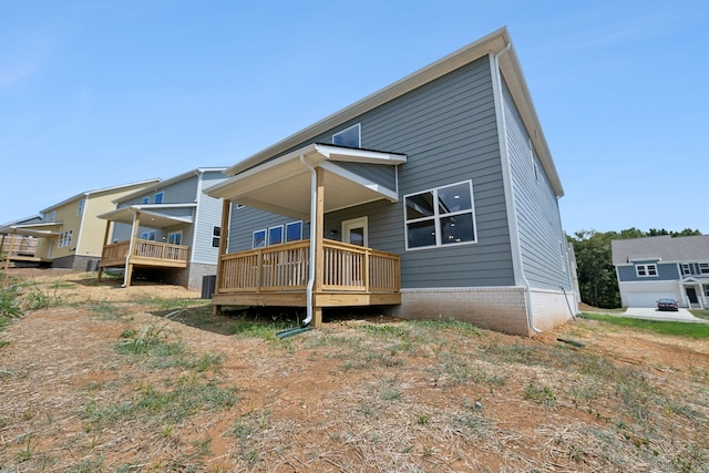 rear view of house featuring a wooden deck