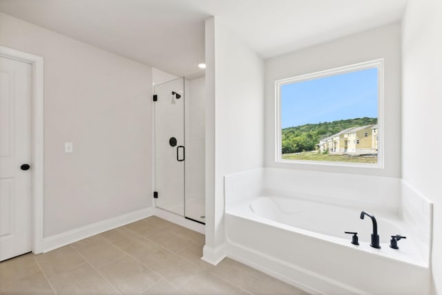 full bathroom featuring a garden tub, tile patterned flooring, baseboards, and a stall shower