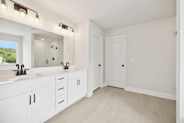 full bath featuring a stall shower, a sink, baseboards, and double vanity