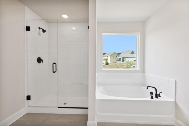 full bathroom featuring baseboards, a stall shower, a bath, and tile patterned floors