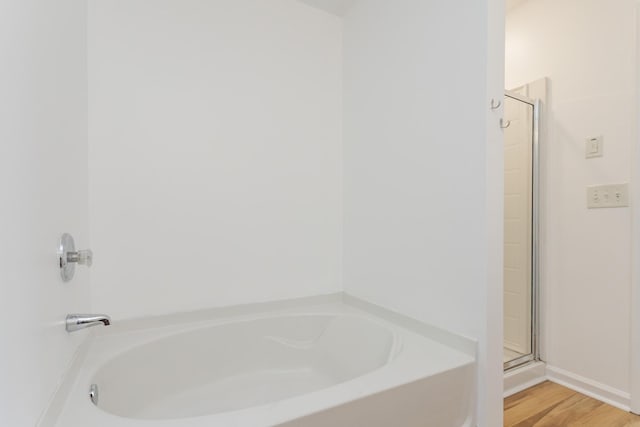 full bathroom featuring a garden tub, wood finished floors, and a stall shower