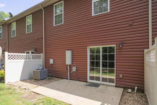 rear view of property featuring fence, central AC, and a patio