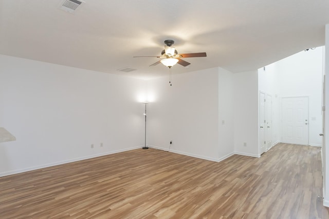 unfurnished room with light wood-style floors, ceiling fan, visible vents, and baseboards