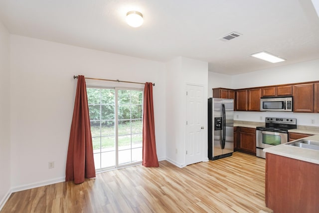 kitchen with light countertops, visible vents, appliances with stainless steel finishes, light wood-style floors, and baseboards