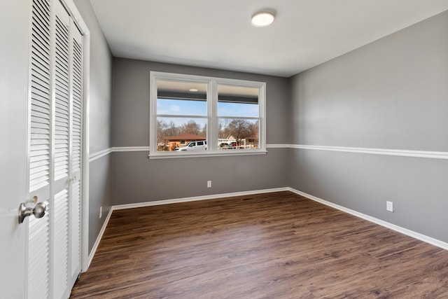 unfurnished bedroom with baseboards, a closet, and wood finished floors