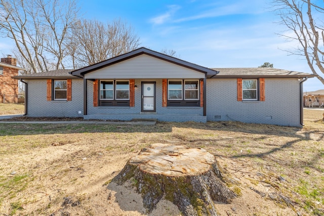 ranch-style home featuring brick siding, crawl space, a shingled roof, and a front lawn