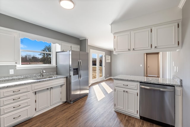 kitchen featuring appliances with stainless steel finishes, a sink, and white cabinets