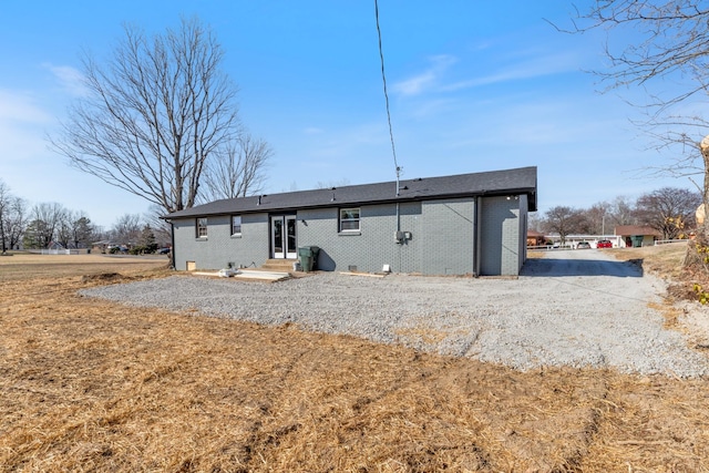 rear view of property with entry steps and brick siding