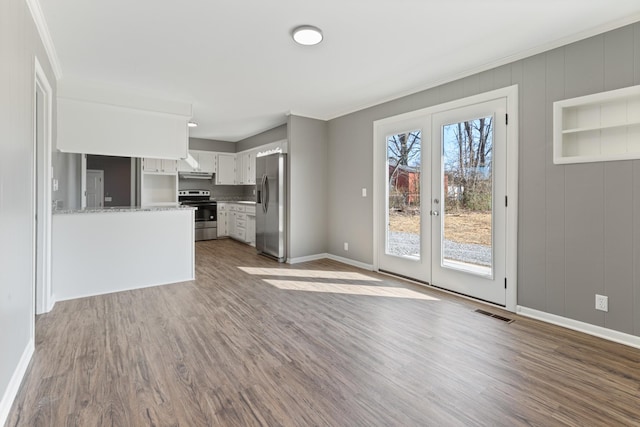 unfurnished living room with crown molding, french doors, dark wood finished floors, and baseboards