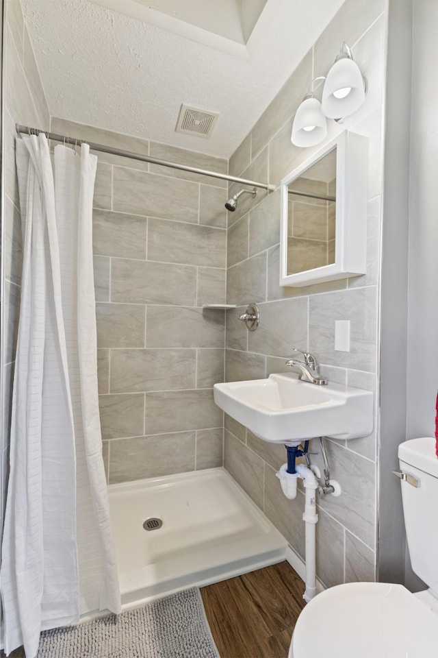 100 Eleazer Dr, Dickson, TN 37055 - full bath with visible vents, wood finished floors, toilet, tile walls, and a shower stall