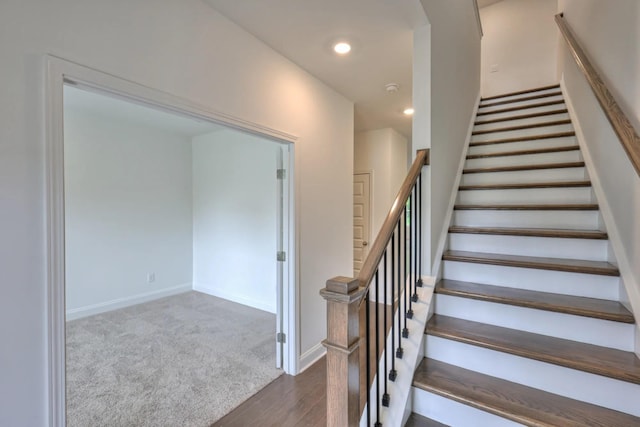 stairway with baseboards, carpet floors, wood finished floors, and recessed lighting