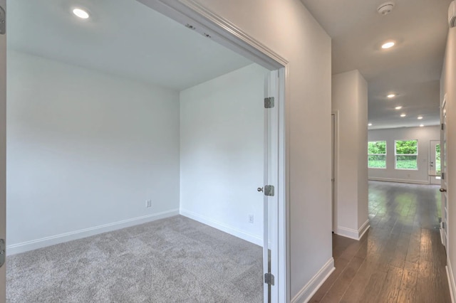 hallway featuring dark wood-style floors, baseboards, and recessed lighting