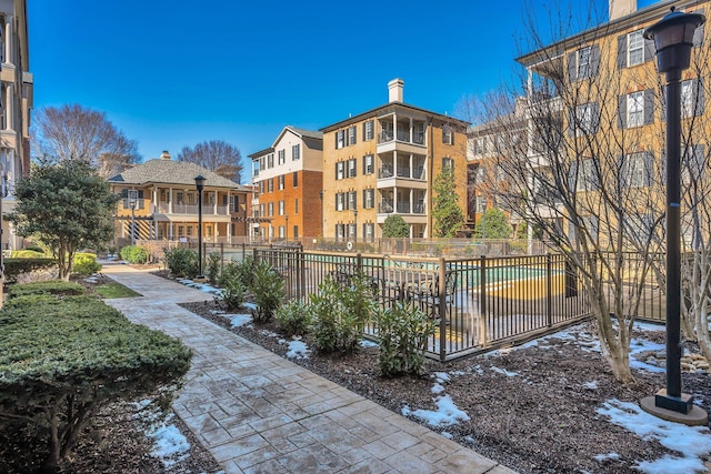 view of property's community featuring a pool and fence