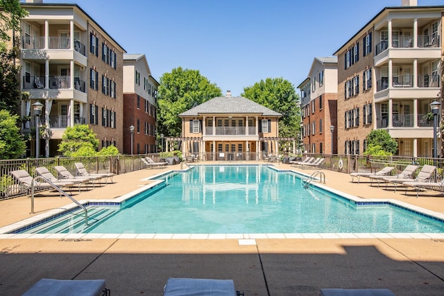 community pool with fence and a patio