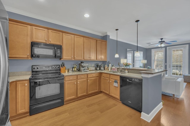 kitchen featuring ornamental molding, open floor plan, a sink, and black appliances