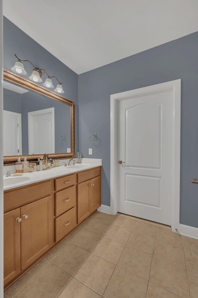 full bathroom featuring double vanity, tile patterned flooring, baseboards, and a sink