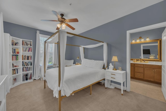 bedroom with ceiling fan, light tile patterned floors, connected bathroom, and light colored carpet