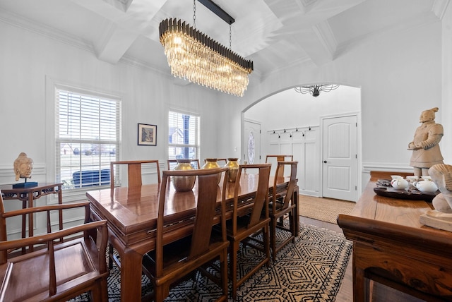 dining room with a chandelier, arched walkways, coffered ceiling, beam ceiling, and crown molding