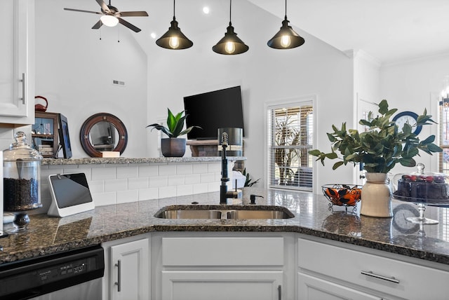 kitchen with dishwasher, decorative backsplash, a sink, and white cabinets