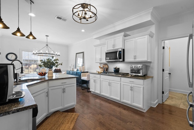 kitchen featuring a notable chandelier, stainless steel appliances, a sink, visible vents, and ornamental molding