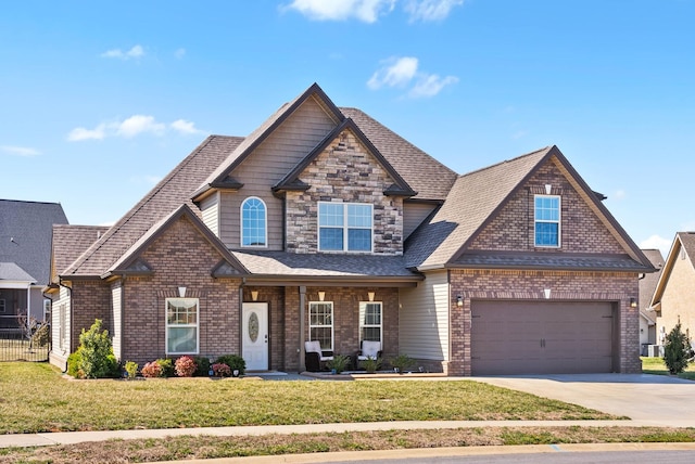 craftsman inspired home with a garage, brick siding, driveway, roof with shingles, and a front lawn