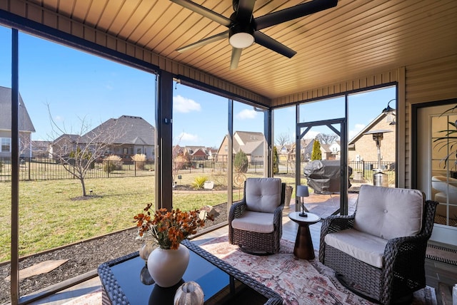 sunroom with plenty of natural light, a residential view, and ceiling fan