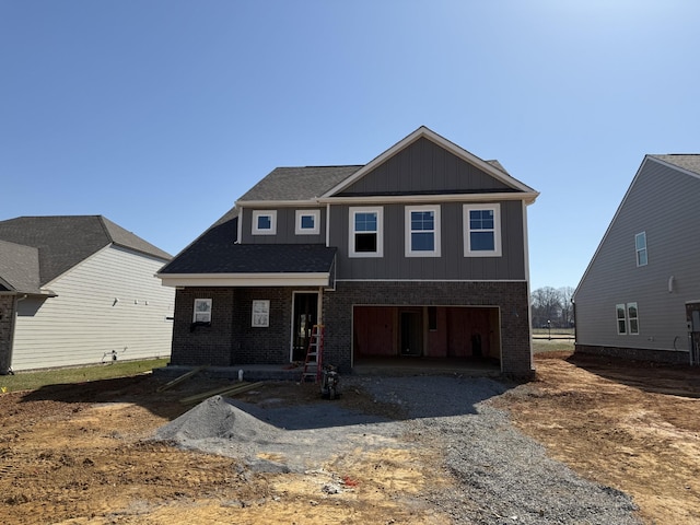 view of front of property featuring an attached garage, brick siding, and driveway