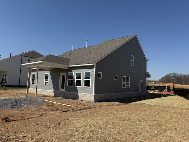 rear view of house with a shingled roof