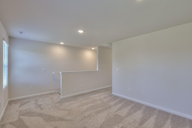 spare room with light carpet, visible vents, baseboards, a wealth of natural light, and recessed lighting