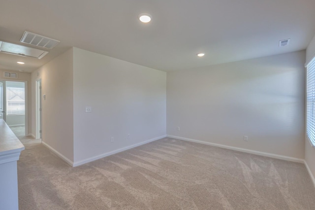 spare room featuring recessed lighting, visible vents, and baseboards