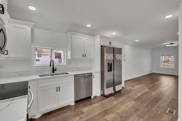 kitchen with a healthy amount of sunlight, white cabinets, stainless steel appliances, and a sink