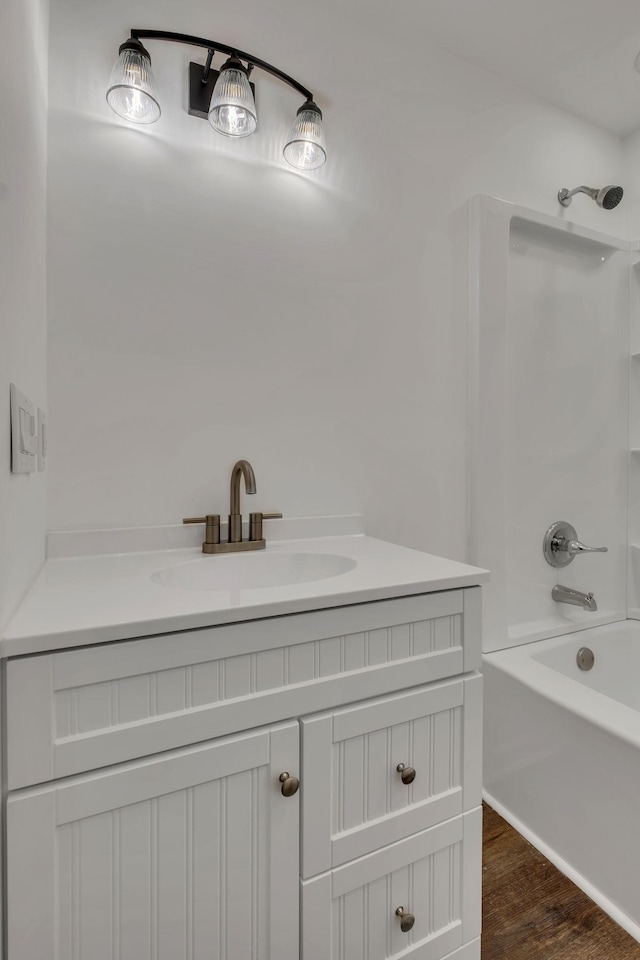 full bath featuring shower / bath combination, wood finished floors, and vanity