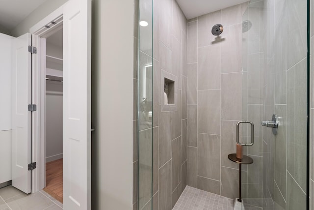 bathroom with a spacious closet and a stall shower