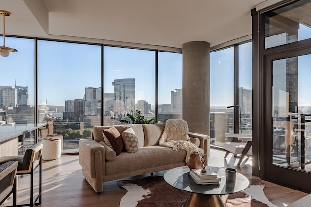 living area with a view of city, wood finished floors, and expansive windows