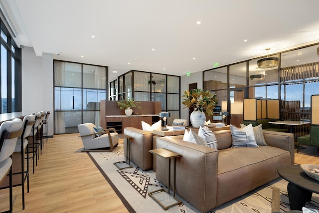 living room with recessed lighting, light wood-style floors, and expansive windows