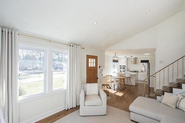 living area with stairway, wood finished floors, and a healthy amount of sunlight