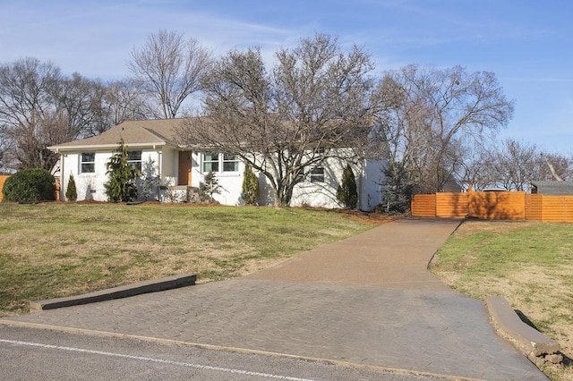 view of front of house with a front yard, fence, and driveway