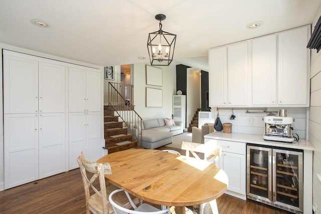 kitchen with wine cooler, dark wood-type flooring, light countertops, white cabinetry, and pendant lighting