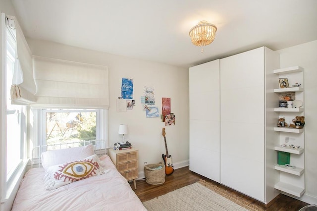 bedroom featuring dark wood finished floors and baseboards