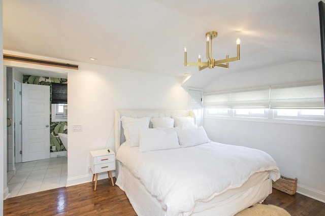 bedroom with an inviting chandelier, baseboards, vaulted ceiling, and wood finished floors