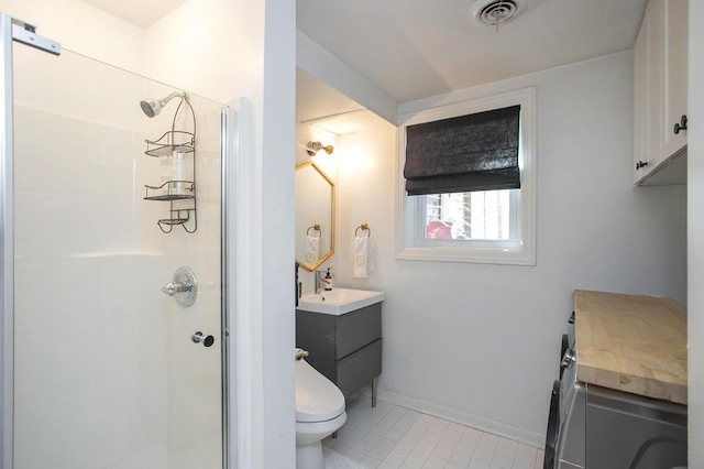 bathroom with toilet, vanity, visible vents, baseboards, and a shower stall