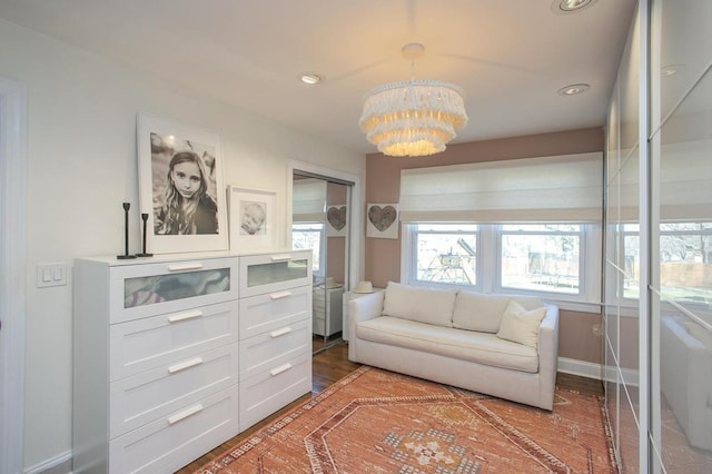 living area featuring baseboards, recessed lighting, and a notable chandelier