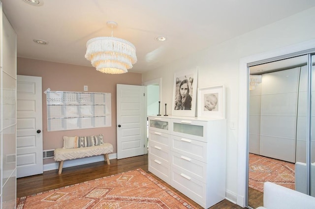 interior space with visible vents, a notable chandelier, and wood finished floors