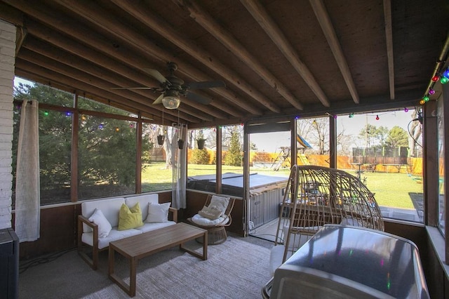 sunroom featuring lofted ceiling with beams and ceiling fan