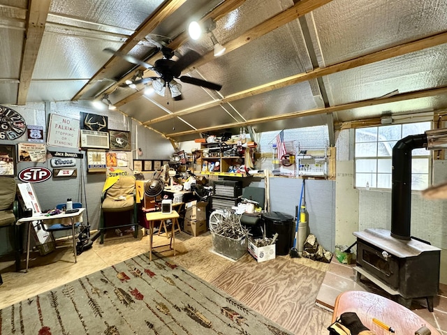 miscellaneous room with lofted ceiling, a wood stove, and a ceiling fan