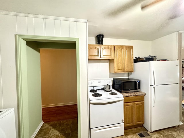 kitchen with light countertops, visible vents, a textured ceiling, white appliances, and baseboards