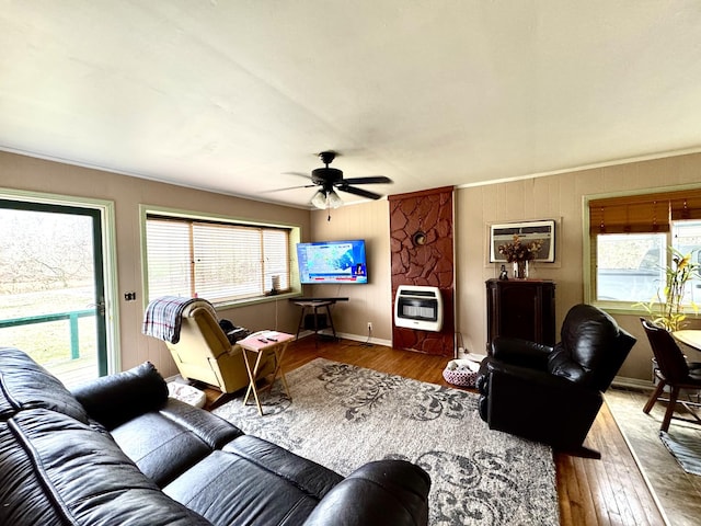 living room with baseboards, hardwood / wood-style floors, a ceiling fan, and heating unit