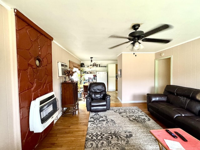 living room featuring crown molding, light wood-style flooring, heating unit, and ceiling fan