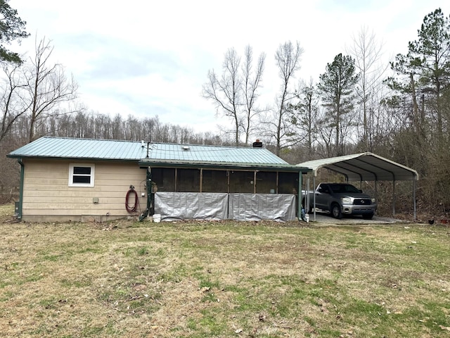 exterior space featuring a sunroom, metal roof, a carport, and a yard