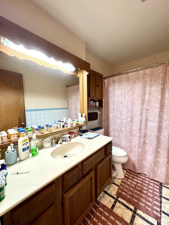 full bath featuring toilet, a shower with shower curtain, tile walls, and vanity